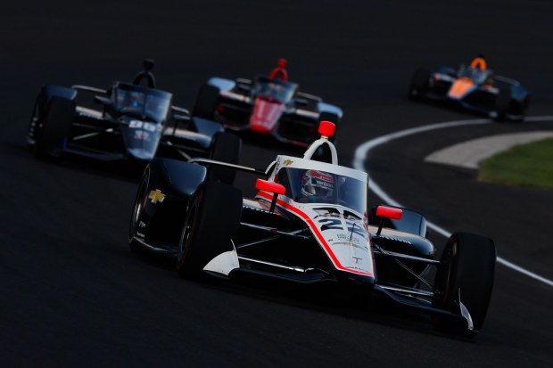 Will Power leads a pack of cars at Indianapolis Motor Speedway.
