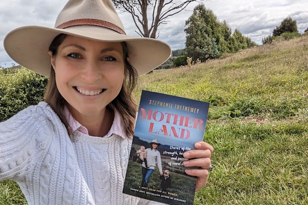 Stephanie Trethewey holding her  debut book, Motherland.