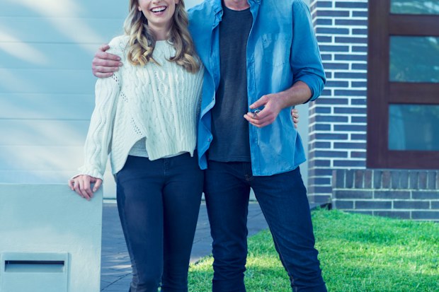 Young couple in front of home