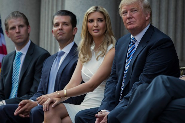 Donald Trump, right, sits with his children, from left, Eric Trump, Donald Trump Jr., and Ivanka Trump during a groundbreaking ceremony for the Trump International Hotel on July 23, 2014, in Washington. 