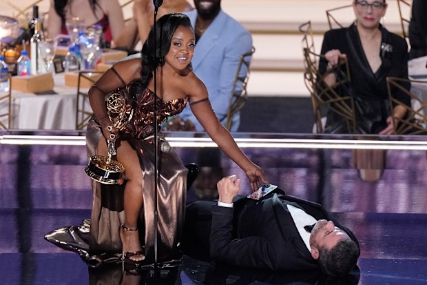 Quinta Brunson, right, winner of the Emmy for outstanding writing for a comedy series for "Abbott Elementary", checks on Jimmy Kimmel as he lays on stage at the 74th Primetime Emmy Awards