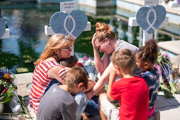 The friends of family of Miranda Mathis grieve her loss in front of a cross bearing her name in Uvalde, Tx., U.S., on Thursday, May 26, 2022. 