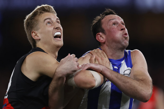 MELBOURNE, AUSTRALIA - AUGUST 12: Nick Bryan of the Bombers  competes with Todd Goldstein of the Kangaroos during the round 22 AFL match between North Melbourne Kangaroos and Essendon Bombers at Marvel Stadium, on August 12, 2023, in Melbourne, Australia. (Photo by Darrian Traynor/Getty Images)