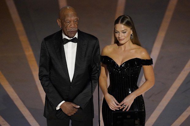 Morgan Freeman, left, and Margot Robbie speak about Warner Brothers 100 years anniversary at the Oscars on Sunday, March 12, 2023, at the Dolby Theatre in Los Angeles. (AP Photo/Chris Pizzello)