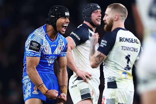 Stephen Crichton of Samoa celebrates after kicking a dropped goal, leading to Samoa winning the game as Sam Tomkins of England looks dejected  during the Rugby League World Cup Semi-Final match between  England and Samoa at Emirates Stadium on November 12, 2022 in London, England. (Photo by Michael Steele/Getty Images)