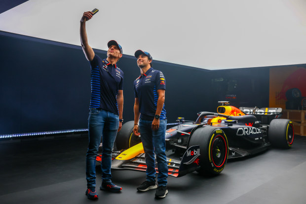 Max Verstappen (left) with Red Bull teammate Sergio Perez and the new RB20.