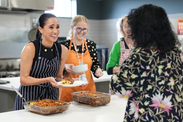 Meghan, Duchess of Sussex and staff at McAuley Community Services for Women, a women's homeless and family violence shelter, serves lunch to a resident on April 14, 2026 in the Footscray suburb of Melbourne, Australia. Meghan and Prince Harry, Duke of Sussex are on a four-day visit to Australia, with engagements across Melbourne, Canberra and Sydney. (Photo by Jonathan Brady-Pool/Getty Images)
