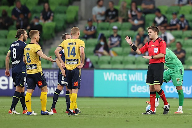Referee Adam Kersey speaks to players as he awaits a VAR decision during the match between Melbourne Victory and Central Coast Mariners at AAMI Park.
