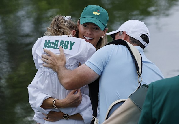 Rory McIlroy of Northern Ireland  and his wife, Erica Stoll embrace their daughter, Poppy McIlroy