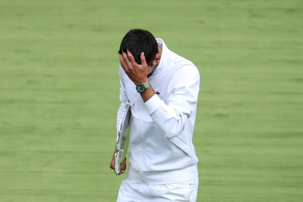 Novak Djokovic puts his head in his hand in the men's final at Wimbledon.