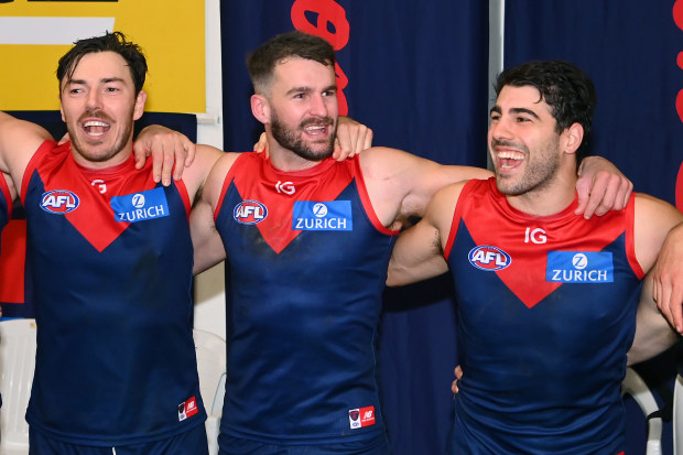 (From left) Michael Hibberd, Joel Smith and Christian Petracca of the Demons sings after winning the round 13 AFL match between Melbourne Demons and Collingwood Magpies.