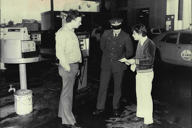 Fuel rationing... a policeman checks a driver at a City service station. June 20, 1979.