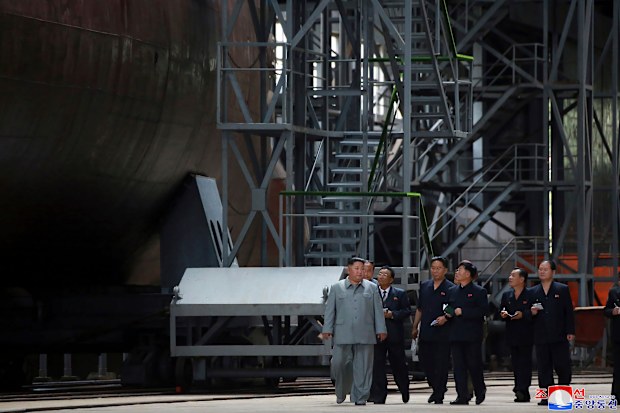 North Korean leader Kim Jong Un, left, inspects a newly built submarine to be deployed soon, at an unknown location in North Korea. 