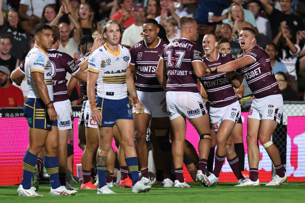 Sea Eagles players celebrate the try scored by Brad Parker