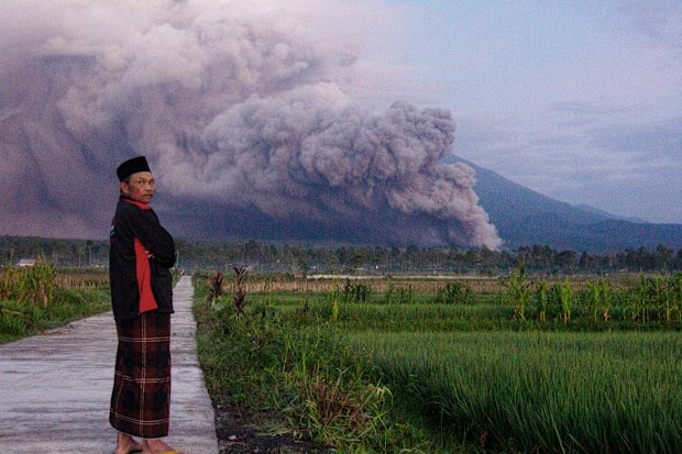 A man looks on as Mount Semeru releases volcanic materials during an eruption on Sunday, in Lumajang, East java, Indonesia.