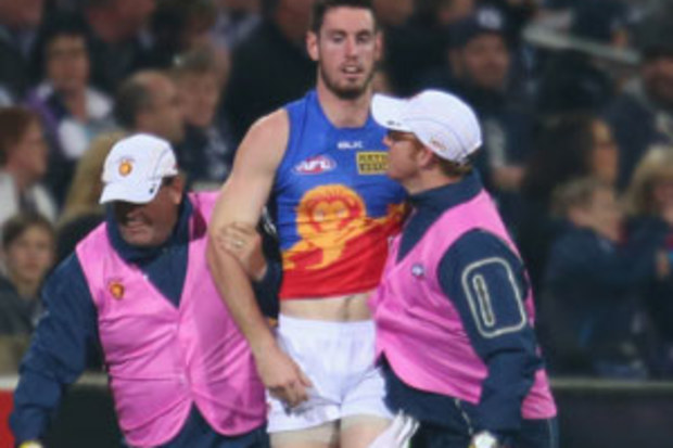 Brisbane Lions defender Darcy Gardiner is helped from the field after suffering concussion from a 'falcon'. (Getty)