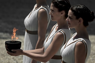 The modern Olympic flame is ignited at the site where the temple of Hestia used to stand. In&nbsp;Ancient Greek religion,&nbsp;Hestia&nbsp;is a virgin&nbsp;goddess&nbsp;of the&nbsp;hearth,&nbsp;architecture, and the right ordering of domesticity, the family, and the state.