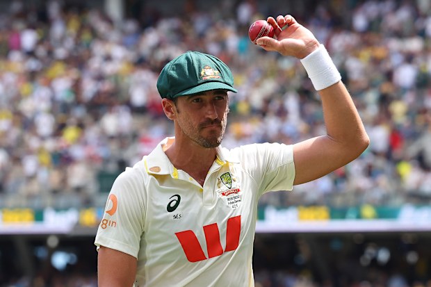 Mitchell Starc of Australia holds the ball aloft after taking 7 for 58