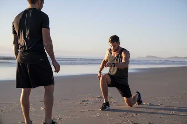 Chris Hemsworth working out with Luke Zocchi on a beach