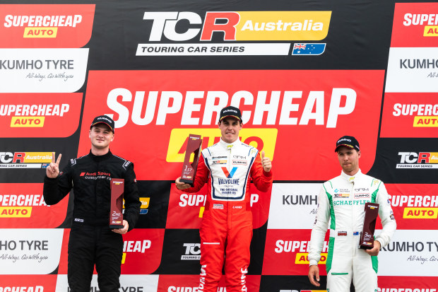 Aaron Cameron (middle) stands atop the podium with Jordan Cox (right) and Lachlan Mineeff.