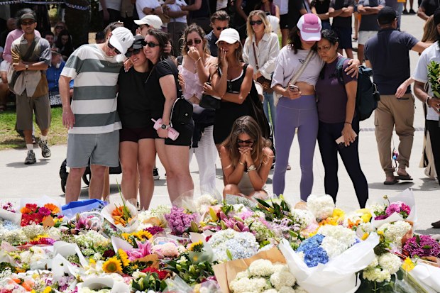 Emotions are high as locals continue to flock to Bondi Beach to lay flowers.