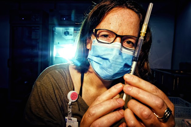 St Vincent Hospital Pharmacist Deputy Director Helen Dixon prepares a vaccination at the Royal Exhibition Building vaccination hub in Melbourne.