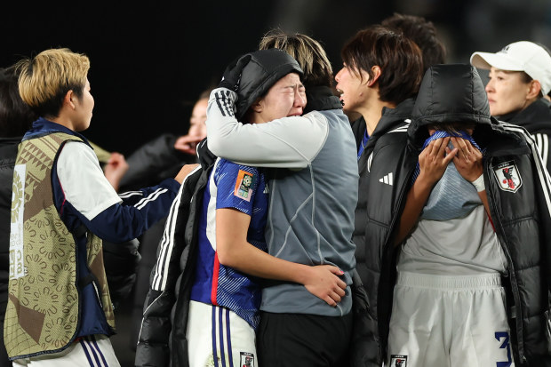 Jun Endo of Japan is consoled by her teammates after the team's 1-2 defeat and elimination from the tournament.