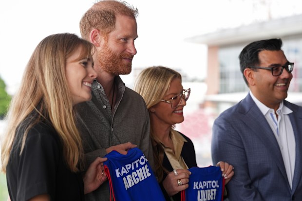 Britain's Prince Harry, the Duke of Sussex, is presented with Western Bulldogs Archie and Lilibet jerseys during a visit to Movember at the Western Bulldogs Headquarters at Mission Whitten Oval, in Footscray, Melbourne, Australia, Wednesday, April 15, 2026. (Jonathan Brady/Pool Photo via AP)