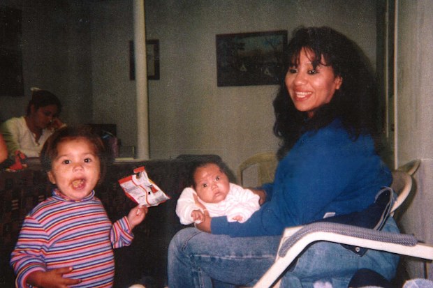 Texas death row inmate Melissa Lucio is holding her daughter Mariah, while one of her other daughters, Adriana, stands next to them. 