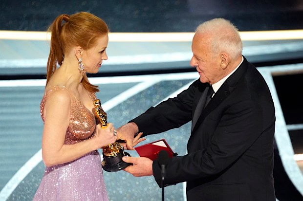 Anthony Hopkins, right, presents Jessica Chastain with the award for best performance by an actress in a leading role for "The Eyes of Tammy Faye" at the Oscars on Sunday, March 27, 2022, at the Dolby Theatre in Los Angeles. (AP Photo/Chris Pizzello)
