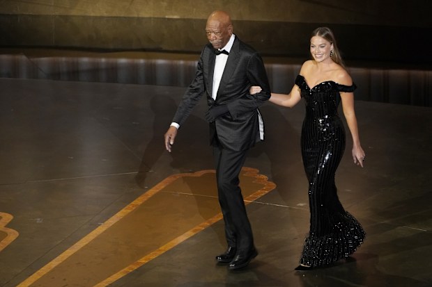 Morgan Freeman, left, and Margot Robbie are seen walking onstage at the Oscars on Sunday, March 12, 2023, at the Dolby Theatre in Los Angeles. (AP Photo/Chris Pizzello)