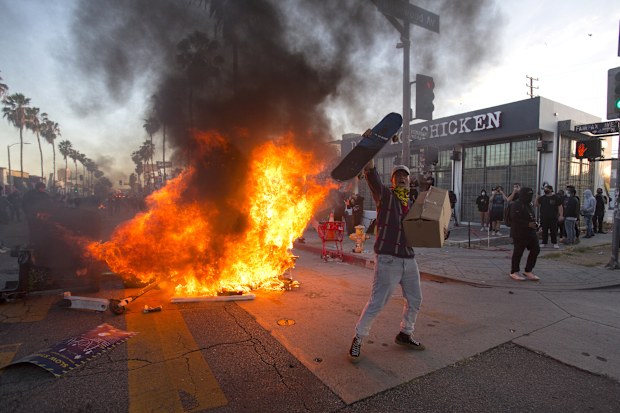 A protester shouts in front of a fire during a protest in Los Angeles