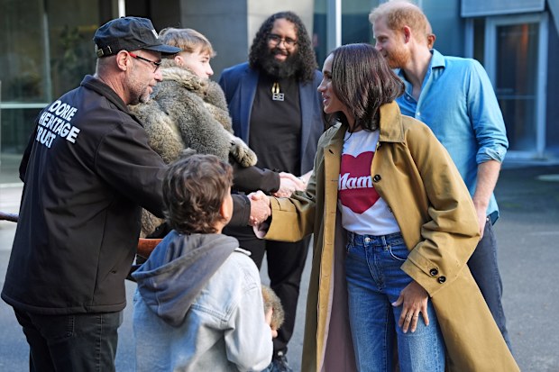 MELBOURNE, AUSTRALIA - APRIL 16: Anthony Appo, 9, shows an indigenous Marngrook ball to the Duke and Duchess of Sussex, Prince Harry and Meghan Markle as they meet representatives from the Koorie Heritage Trust before taking part in the Scar Tree Walk on day three of the royal trip on April 16, 2026 in Melbourne, Australia. The Scar Tree Walk is a journey connecting traditional and contemporary Aboriginal cultures and histories of the Kulin Nation. The Duke and Duchess of Sussex are on a four-da