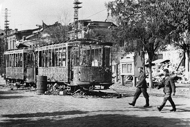 Nazi soldiers are seen here crossing a street in Vernolejinsk in the Southern Ukraine on Sept. 3, 1941 after the Russians had evacuated it. Note the burnt-out street cars in the centre of the road fired by the Russians in accordance with their 'Scorched Earth' policy before they left. (AP Photo)