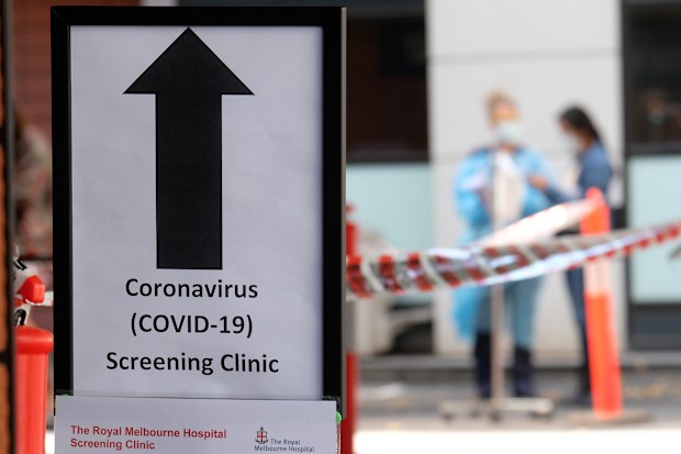 MELBOURNE, AUSTRALIA - MARCH 11: A sign directing people to the COVID-19 screening area is posted outside the Royal Melbourne Hospital on March 11, 2020 in Melbourne, Australia. Seven coronavirus screening clinics are now open in Victoria to help avoid the further spread of COVID-19. 18 people in Victoria have now been diagnosed with the virus, with the Australian total of confirmed cases now at 100.(Photo by Luis Ascui/Getty Images)
