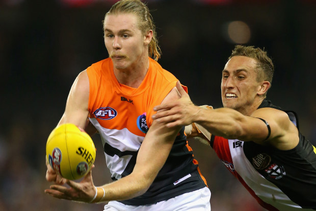 Cam McCarthy of the Giants handballs whilst being tackled by Luke Dunstan of the Saints during the round one AFL match between the St Kilda Saints and the Greater Western Sydney Giants at Etihad Stadium on April 5, 2015 in Melbourne, Australia. (Photo by Quinn Rooney/Getty Images)