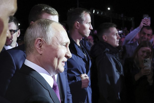 Russian President Vladimir Putin, left, talks with people during his visit a memorial for the heroes of the World War II Battle of Kursk, in the village of Ponyri, near Kursk, Russia, Wednesday, Aug. 23, 2023. 
