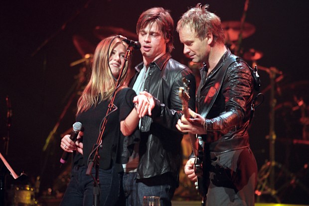 Jennifer Aniston and Brad Pitt show off Jennifer's engagement ring onstage at the Beacon Theater during a Sting concert on November 21, 1999.