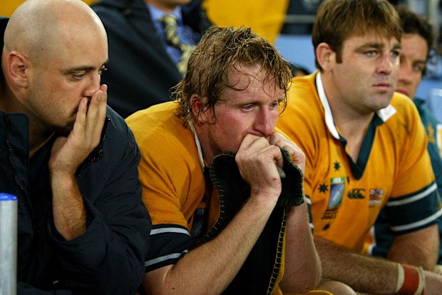 Dejected Wallabies Nathan Sharpe, Bill Young and David Lyons watch England celebrate in 2003.