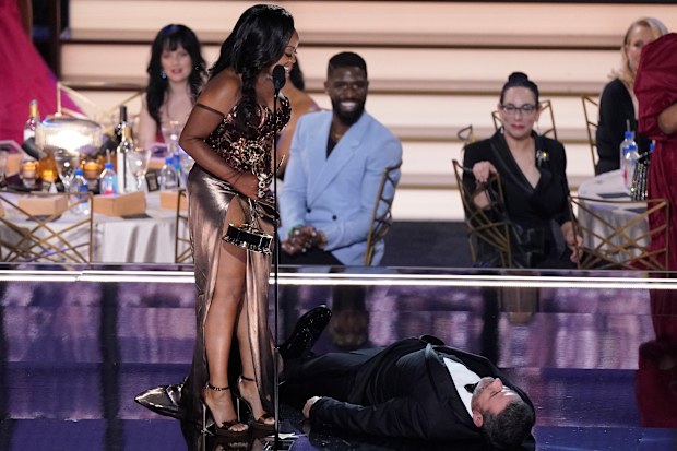 Quinta Brunson, right, winner of the Emmy for outstanding writing for a comedy series for "Abbott Elementary", checks on Jimmy Kimmel as he lays on stage at the 74th Primetime Emmy Awards