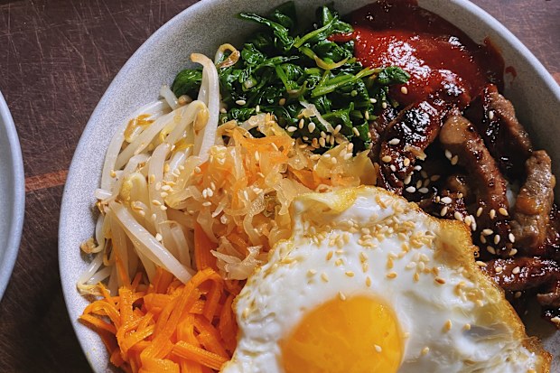 A bowl of beef bibimbap, with veggies and an egg