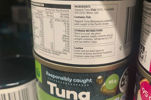 Tuna cans in the shelves in a Woolworths store.