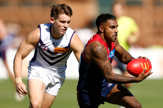 Kysaiah Pickett of the Demons is tackled by Caleb Serong of the Dockers in 2024.