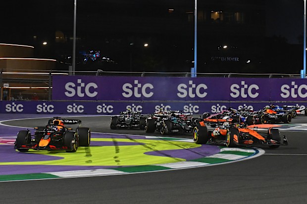 Max Verstappen of Oracle Red Bull Racing (left) runs wide as Oscar Piastri of Mercedes leads in Saudi Arabia.