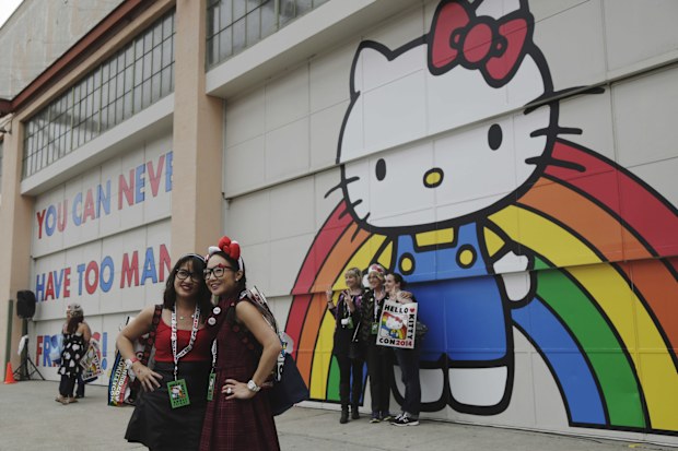 LOS ANGELES, CA - OCTOBER 31: Tina Chinakarn, left, and Julie To, right, take a picture in front of a Hello Kitty mural outside of Hello Kitty Con October 31, 2014 at The Geffen Contemporary at MOCA in Los Angeles, California. Some 25,000 fans are expected to attend Hello Kitty Con between October 30 and November 2. The event celebrates 40 years of the Sanrio icon, featuring Hello Kitty merchandise, art installations, a costume contest and more. (Photo by Dan R. Krauss/Getty Images)