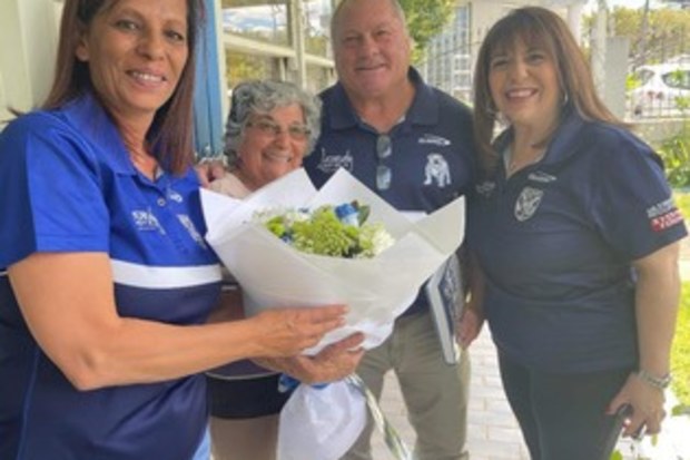 Josie Vincent is presented with flowers by Bulldogs great Terry Lamb.