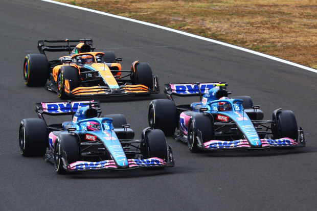 Fernando Alonso of Spain driving the (14) Alpine F1 A522 Renault, Esteban Ocon of France driving the (31) Alpine F1 A522 Renault and Daniel Ricciardo of Australia driving the (3) McLaren MCL36 Mercedes battle for track position during the F1 Grand Prix of Hungary at Hungaroring on July 31, 2022 in Budapest, Hungary. (Photo by Dan Istitene - Formula 1/Formula 1 via Getty Images)