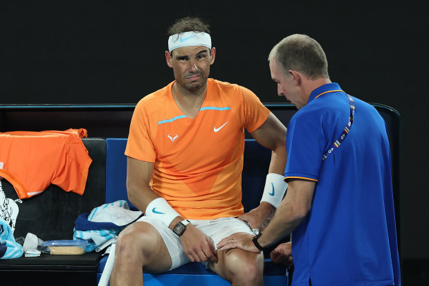 MELBOURNE, AUSTRALIA - JANUARY 18: Rafael Nadal of Spain receives attention during a medical time out in their round two singles match against Mackenzie McDonald of the United States during day three of the 2023 Australian Open at Melbourne Park on January 18, 2023 in Melbourne, Australia. (Photo by Cameron Spencer/Getty Images)