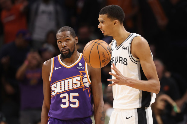 PHOENIX, ARIZONA - NOVEMBER 02: Kevin Durant #35 of the Phoenix Suns talks with Victor Wembanyama #1 of the San Antonio Spurs following the NBA game at Footprint Center on November 02, 2023 in Phoenix, Arizona. The Spurs defeated the Suns 132-121. 