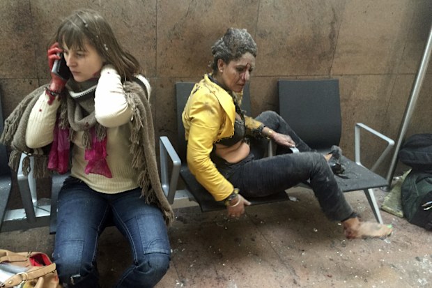 Two injured women sit dazed, confused and covered in dust in Brussels Airport in Belgium, on March 22, 2016. Twin bombings at Brussels airport and a metro station killed 32 people from around the world. Islamic State claimed responsibility for the attack.